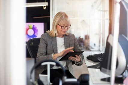 Woman looking at a tablet in an office.