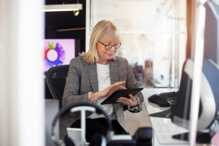 Woman looking at a tablet in an office.