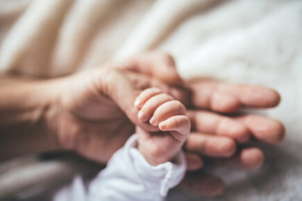 Baby holding onto hands