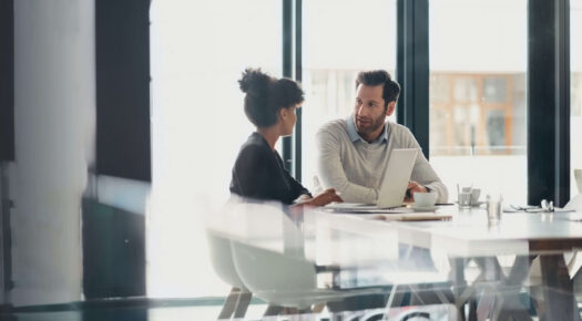 Employees talking at desk